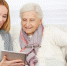 Woman giving senior woman introduction to internet with a tablet computer - Ветеран Башкортостана