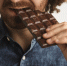 closeup-curly-hair-happy-bearded-man-with-healthy-skin-bites-organic-freshly-baked-chocolate-bar-with-side-of-mouth-close-focus-on-mouth - News102.Ru