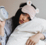 sad-girl-in-pajamas-and-sleep-mask-is-hugging-white-pillow-and-holding-alarm-clock - News102.Ru
