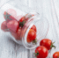 side view of tomatoes spilling out of jar on wooden background - News102.Ru